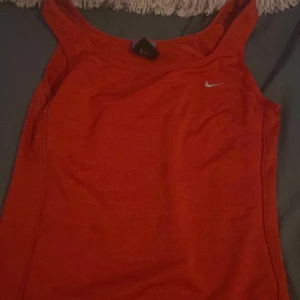 Träningslinne nike - Ett rött nike tränings linne som inte är använd alls för va en present tränar ej drf inte använd den är i bra skick inga lösa trådar. 