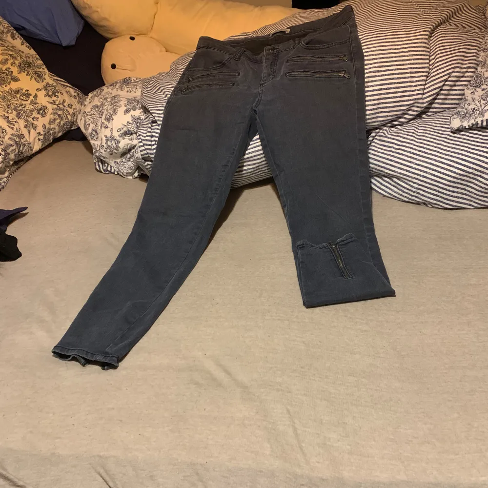 Grå/svarta jeans med dragkedja vid fötterna . Jeans & Byxor.
