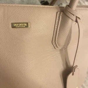 Stor don Donna väska! - Inte använd på nåra år! Beige rosa färg med stort utrymme  Använd som skolväska perfekt storlek för de!