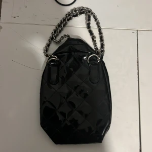 Handväska med silverkedjor - Säljer denna väskan som jag fick som present använder inte för att det inte är min stil (har en liten vit färg som är nästan osynlig)