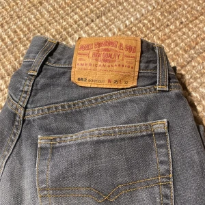 Lågmidjade grå boot cut jeans - W 28 L 32 Fina lågmidjade vintage jeans i bra skick super fina säljer för dom inte passar längre. Om det är fler intresserade tar jag bud.