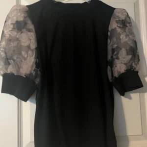 Blus med puffärm - Blus/t-shirt med puffärm i skirt tyg.