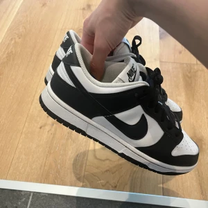 Dunk Low Next Nature  - Säljer dessa Dunk Low Next Nature i färgen white/black. Dem är i använt skick men är fortfarande fina och fräscha. I storlek 39. Köpta för 1300 kr på Zalando för 1 år sedan. 