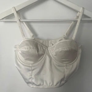 Topp/BH i satin - Väldigt fin topp som liknar en bh. Storlek S, skulle säga passa A kupa eller liten B kupa. Finns inga bilder på pga för liten för mig. I vit satin. Storlek S. Vet ej vart den är köpt ifrån. Men använd fåtal gånger så den är så gott som ny. 