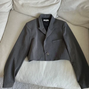 Djerf Avenue It Blazer Grey - Croppad kavaj från Djerf Avenue. Storlek S och lite oversized. Från deras första dropp så kan tänkas att justeringar har gjorts sedan dess. Fint skick men dock har en liten söm släppt vid ena kragen, se sista bild!