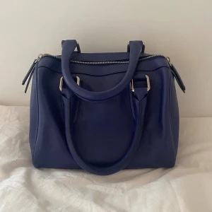 mörkblå väska  - mörkblå handväska i fint skick, väldigt rymlig trots att den är ganska liten! 