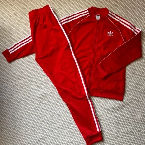 Tracksuit från Adidas. - Adidasset. Rött. Storlek: 13-14Y/164 Fint använt skick, knappt använt.