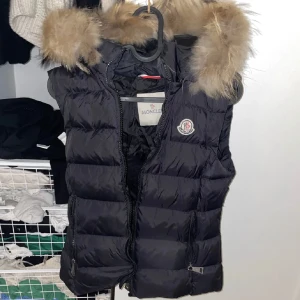 Moncler väst - Moncler väst med avtagbar päls. Storlek xs. Inga hål eller defekter.  Sparsamt använd. Qr-koden finns i västen och kan skickas bild på.