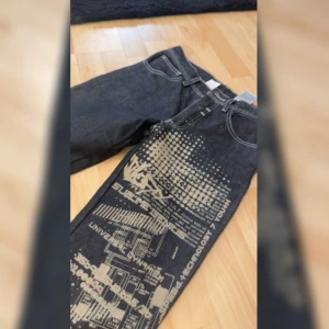 y2k jeans med print - Snygga y2k vintage jeans med cool unikt print. Aldrig använt för de passar inte mig tyvärr.