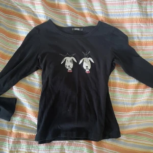 Svart tröja med hundmotiv - En svart långärmad tröja med två broderade hundar på framsidan. Hundarna har kronor på huvudet och röda halsband.