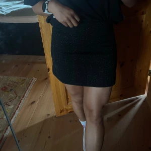 Svart kort kjol - Svart kort kjol med glittriga detaljer