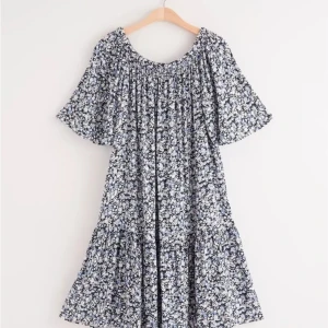 Klänning från Lindex  - Blå/vit blommig off- shoulderklänning från Lindex. Storlek M. I fint begagnat skick. Har rökfritt hem men har hund. 