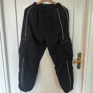 Svarta Activewear/Streetwear Byxor - Svarta byxor i storlek medium, men skulle säga att de är närmre en small/medium. De passar mig som har M/L men är lite tighta i midjan och korta i benen. Väldigt stretchy dock. Använda i ca 1 år.