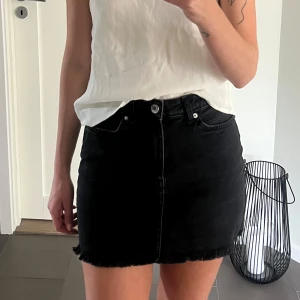 Jeanskjol - Svart/ mörkgrå jeanskjol från Bershka, strl 36. Fint skick!