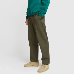 Wood Wood Byxor - Tunna byxor i armygrön från Wood Wood. Modellen heter Stanley Trouser, kostade runt 2000kr nya. Sparsamt använda, mycket fint skick!  Resår i midjan, dragsnören, samt fickor med dragkedjor. Lösare passform, se bild nr.2.  Size: 46 (S) herr. 