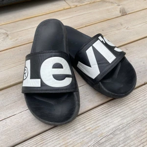 Levi’s Badtofflor - Ett par badtofflor utmärkta att ha med på startanden eller båten eller när du vill. De här sandalerna är i bra skick. Nypris på de här sandalerna är 399kr och jag säljer dem för 150kr. Har du några frågor är det bra att skriva😉😇