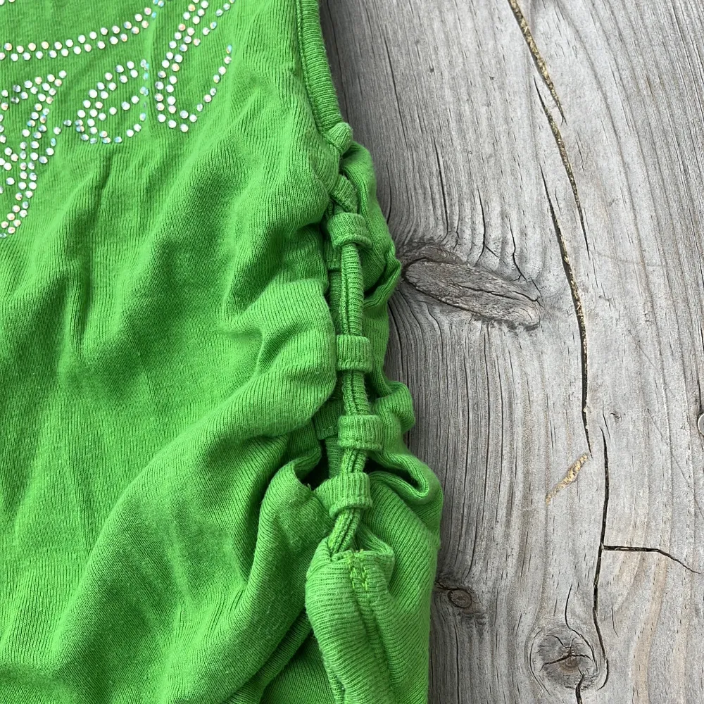 Superfin grön topp från Urban Outfitters med rhinestones och knytningar på sidorna ☺️. Toppar.