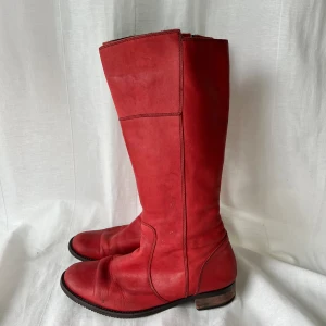 Röda stövlar - Röda stövlar. Har flera defekter, därav priset, men fortfarande användbara. Höjd från häl: 37 cm. Klack: 2,5 cm. Fotsula: ca 25 cm 💕