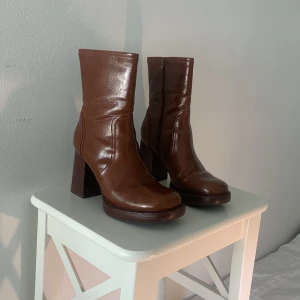 Klack skor  - Säljer bruna läder stövlar. Är ganska använda men förutom skadorna på bilderna så är dom i bra skick. Klacken är 9 cm och det är storlek 39. Pris kan diskuteras. Skriv vid frågor. 