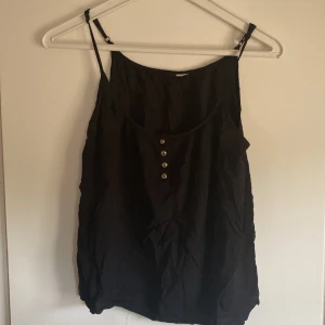 Gulligt linne - Svart gulligt linne med knappdetaljer Behov av strykning pga legat nedpackat 