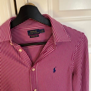 Ralph Lauren - Vit, Rosa randig skjorta - Rosa och Vit randig skjorta från Ralph Lauren. Storlek: XS, passar även XXS. Skick: 10/10, aldrig använd. Nypris: 2000kr. Kontakta mig för fler bilder eller info!