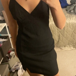 Svart klänning - Svart tunn klänning (inte genomskinlig). Lite öppen i ryggen med korsade band.