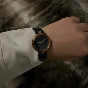 Diamantssima Gucci klocka - Fick som gåva 2021 av min mammas simp men inte kommit till användning.   Klockan har inga repor, skiner  och ser helt ny ut, bandet kan enkelt bytas ut då den blivit lite böjd av min handled.  Rosa guld med äkta  svart läderband.  Nypris 12300kr    