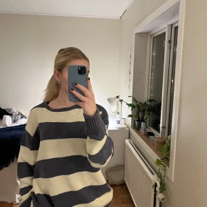 Blå/begie stickad tröja - En supersöt oversized stickad tröja från Brandy Melville.  Nyskick och max använd 2 ggr. Strl: onesize, skulle säga att den passar allt mellan s och xl  