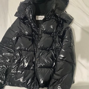 Calvin Clein Shiny vinterjacka - Säljer en Calvin clein shiny jacka i storlek Xs. Den har en jätte liten defekt precis vid slutet av armen men det är inget som syns alls. 