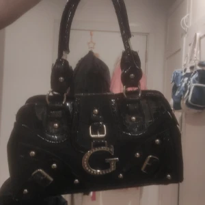 Guess väska  - Vet ej om den är äkta eller inte, köpt fr secondhand för drygt 170, den är sönder på två armgrejer, bild 1&2, men har hållt ut bra