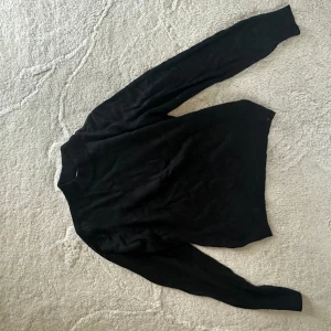 Svart polotröja  - Stickad halvpolo från NAKD. Storlek M