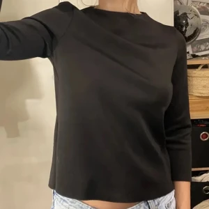 Svart stilren trekvartsärmad tröja - Lånade bilder!! Från Vero Moda. Inga defekter! Ganska hög halsringning. Passar fint som blus eller finkläder till festtillfällen. Dragkedja bak i nacken. Känns lyxig i materialet!