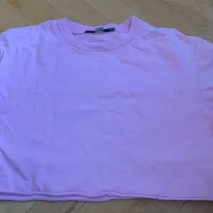 Ett pack med två magtröjor en brun och en rosa. 