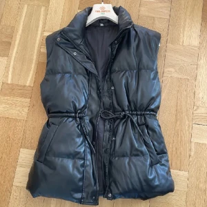 Väst i läderimitation - Tjock väst med knytning i midjan.  220kr inklusive frakt.