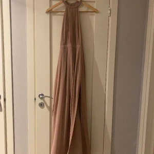 Balklänning NLY Eve - Säljer min balklänning från Nelly i storlek 32 som endast är använd 2 gånger - 1 gång av mig och 1 gång av tjejen jag köpte den av. Från midjebandet är den ca 101cm lång efter att jag sytt upp den lite. Har även en slits på vänster sida. 