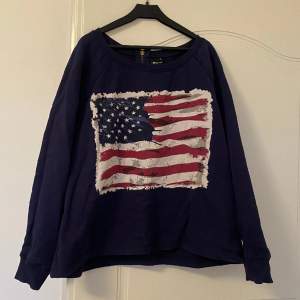 Fin mörk blå sweatshirt från Gina Tricot. Med ett fint tryck av den amerikanska flaggan. 