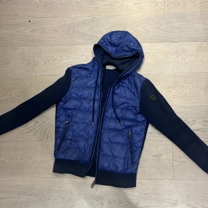Moncler cardigan - Säljer moncler cardigan i storlek s i en väldigt fin marinblå färg i storlek s.Fick även en litet hål på högra sidan vid axeln men lagad hos en skräddare. Skick 6,5 av 10, 
