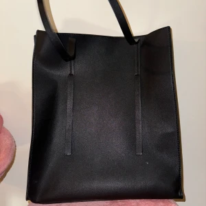 Svart väska  - Svart lite större väska. Perfekt för tex en dator. Fakeskinn. Måttligt använd men i mycket bra skick.