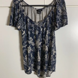 Blå mönstrad blus - En blå blus med vita mönster från Lindex. Aldrig använd. I storlek xs men skulle säga att den passar xs-s. Pris kan diskuteras!