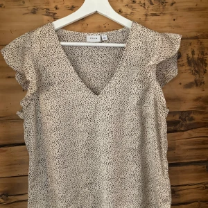 Blus från Vila - Snygg, småprickig blus. Stl 38 men är något stor i stl. 100% polyester. Sparsamt använd 