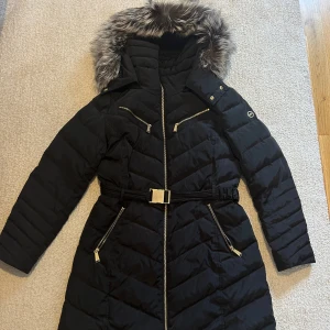 Svart Michael Kors jacka med äkta päls  - Svart Michael Kors jacka med ÄKTA päls, ett bälte och guldiga detaljer. Väldigt bra skick 💕 priset kan diskuteras💕