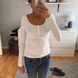 Vit långärmad med knappar🤍 - Säljer en jätte fin långärmad vit tröja med knappar framtill och lite öppen i ryggen. Inte använd så många gånger och säljer den för att jag inte brukar använda den längre. Inga fläckar eller hål. Jätte gott skick. Mer bilder privat!