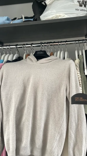 Oscar Jacobson Cashmere hoodie - Hej jag säljer nu min beiga Oscar Jacobson hoodie som jag har bara använt några gånger. Jag säljer den för den är för liten för mig och sist jag använde den så fick den ett litet hål. Passar 165-175, size XS. Skick 9/10, original pris 1500, mitt pris 1199