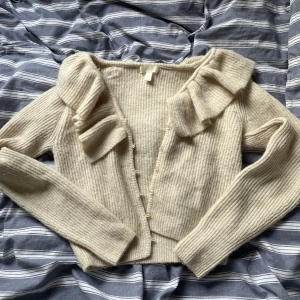 Stickad kofta  - Stickad kofta med volang och knappar från HM.