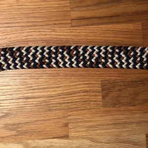 Flätat bälte  - Säljer det här nya och oanvända flätade bältet. Hela bältet bortsett från metallbiten är ca 98 cm långt, men kan stretchas ut till en större storlek. Pris: 99 kr. 