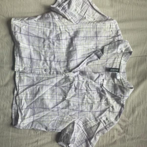 Cropped shirt  - En ljuslila, kort och rutig skjorta från HM, med ljusgröna ränder. 100% bomull, orginalpris 99kr.