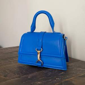 Blå handväska från H&M. Skicket är top notch då den inte har kommit till användning! Axelband tillkommer inte 💙🦋🐬🫐