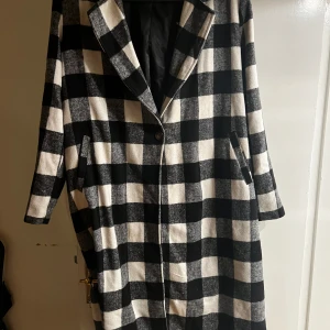 Kappa  - Knälång kappa  Osäker på vart den är köpt då och lappen är borta Knäpps med en knapp strax under bröstet Storleken saknas, men uppskattar den till en storlek 42 om man vill ha den tight. Vill minnas att den va onesize   Något ytluddig, annars ua 