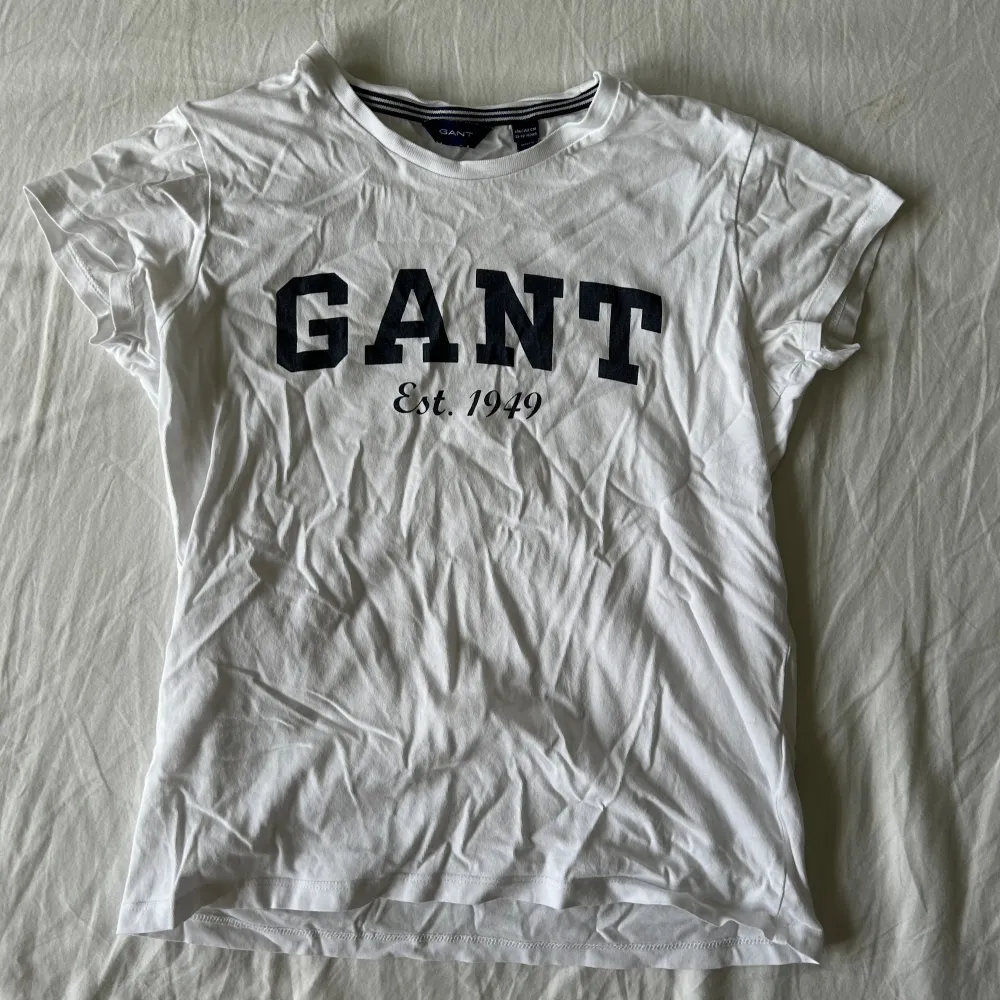 Hej, jag säljer denna vita Gant T-shirt. Den är i bra skick och har nästan inga tecken på användning.. T-shirts.