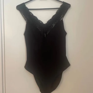 Topp/body - v ringad topp/body med fin spets upptill. Bra och skön material. 